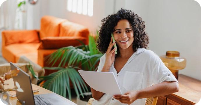 Woman smiling and working on laptop in office
