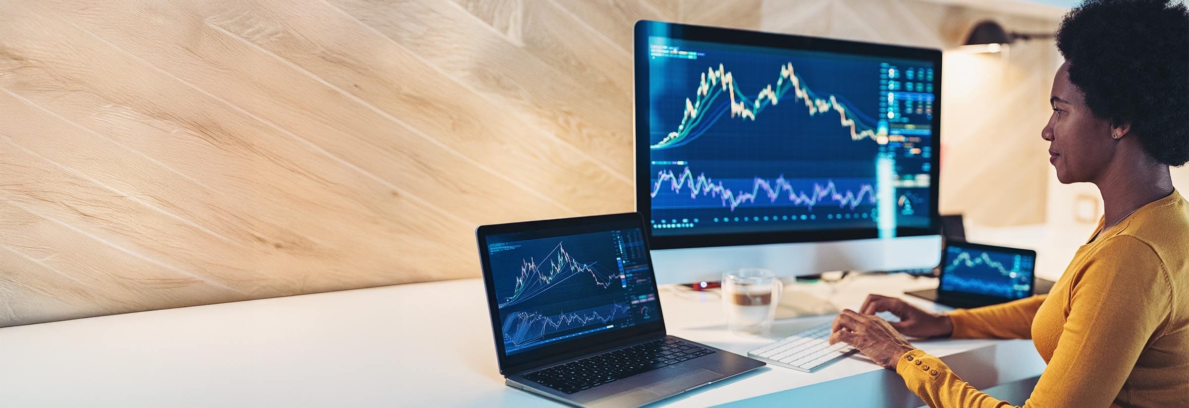 A woman looking at a screen displaying data trends.