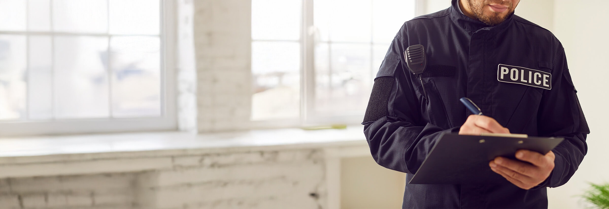 Image of a uniformed police officer filing a credit card theft report.