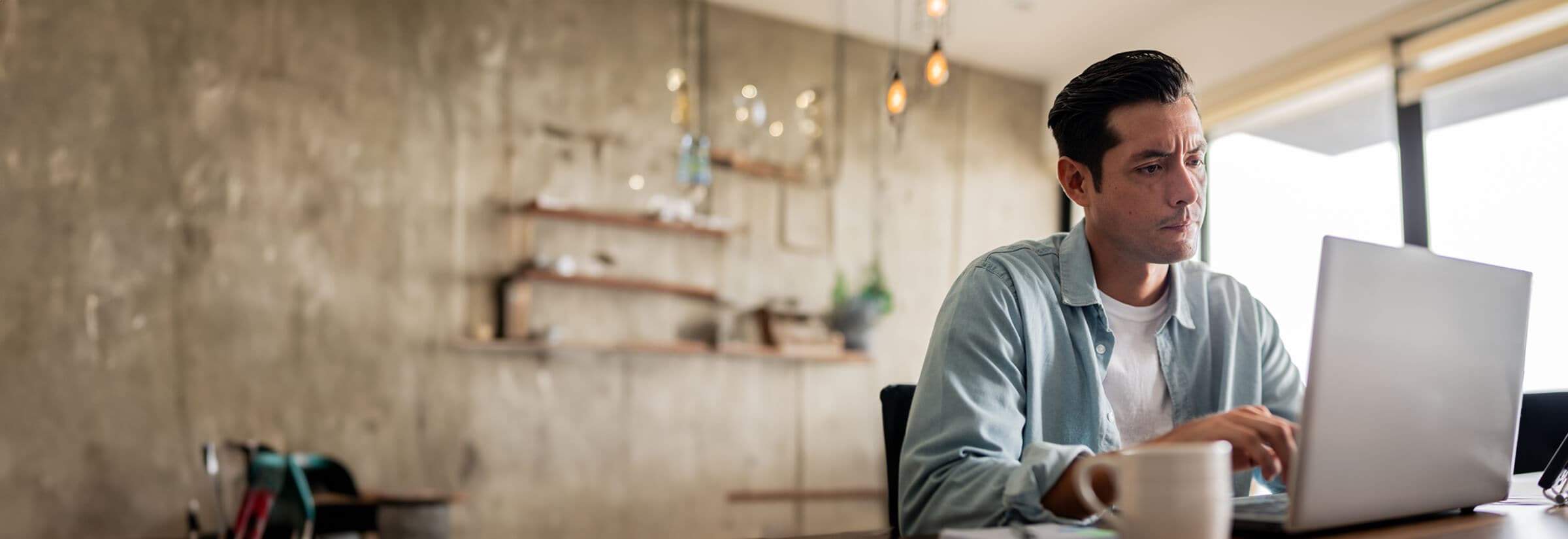 An Image of a man reading a Geek Squad scam email on his laptop.