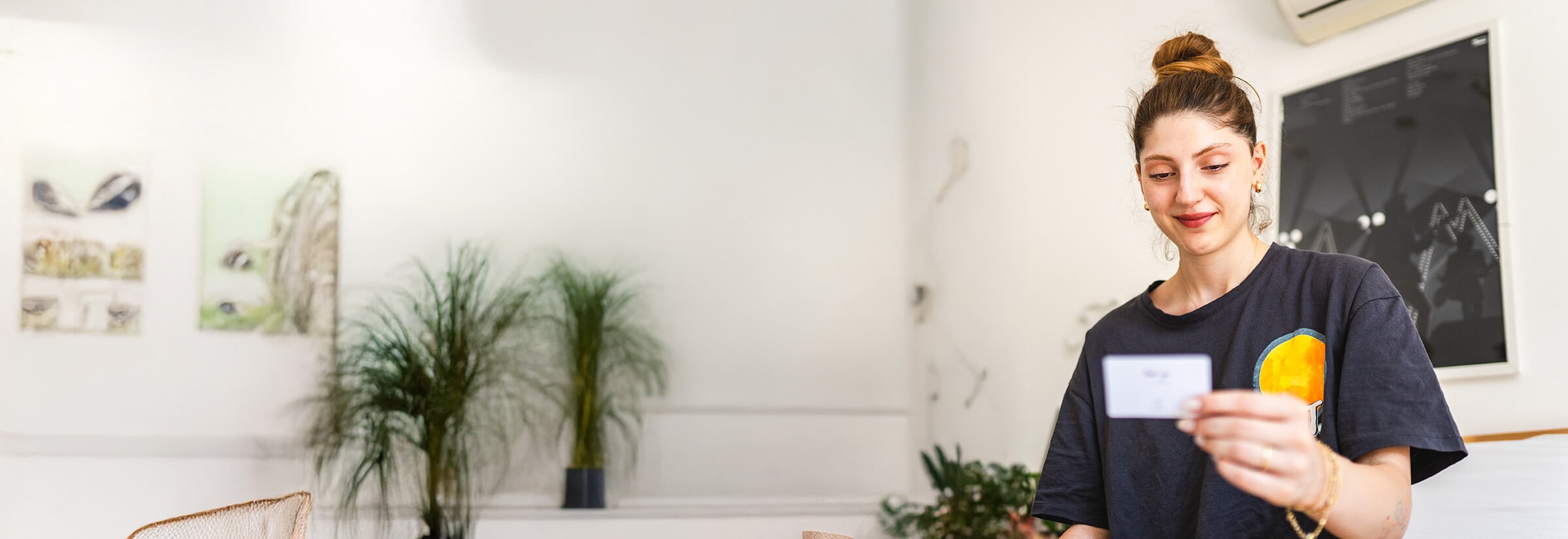 Woman holding and looking at a gift card.