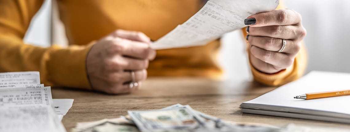 A woman holding a receipt at a desk