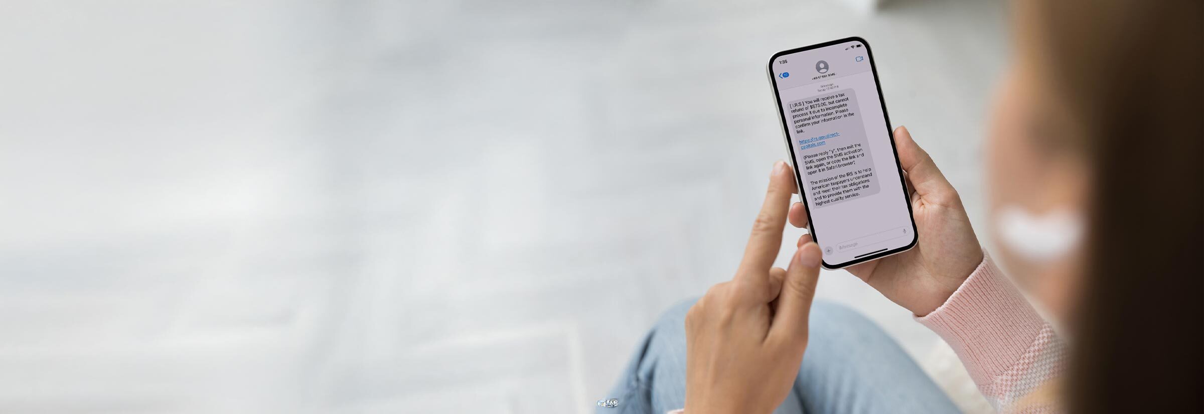 A person holding a smartphone looks at a text message.