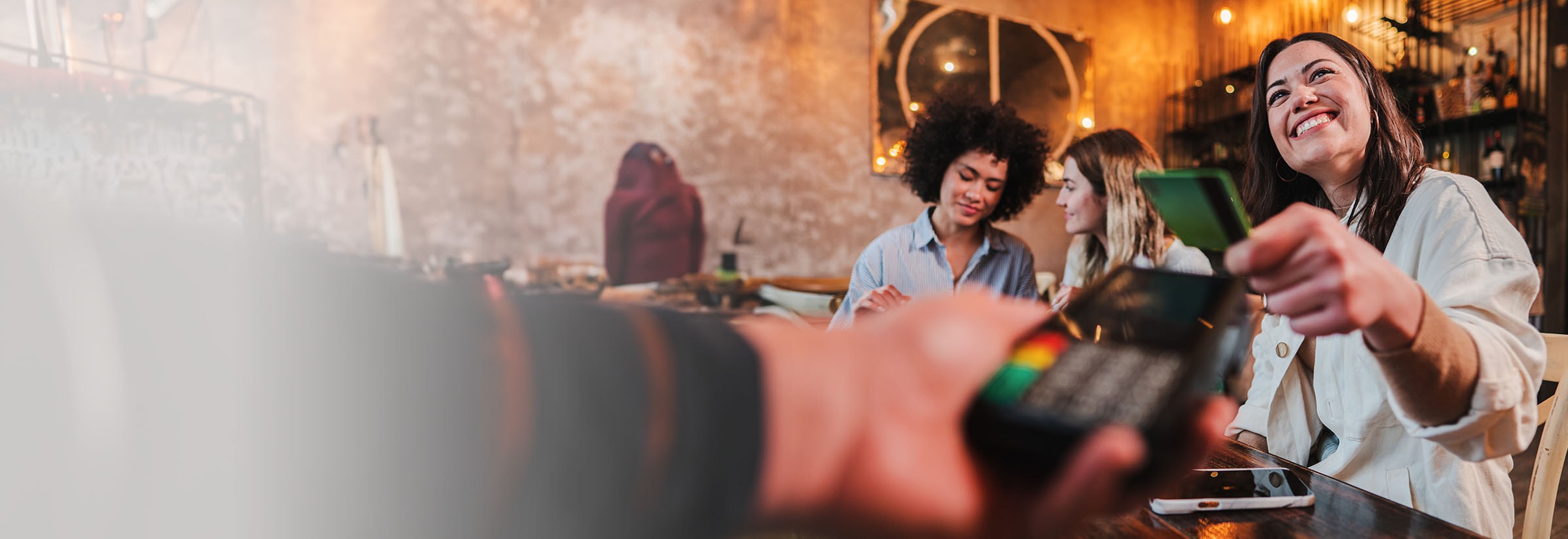 A woman making a contactless card payment.
