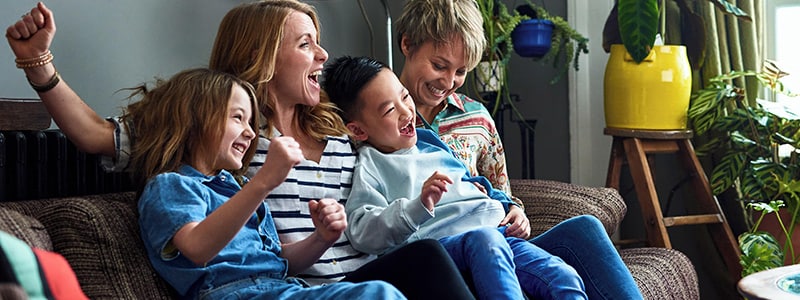 A family of four sit on a couch and are happy to stay safe online.