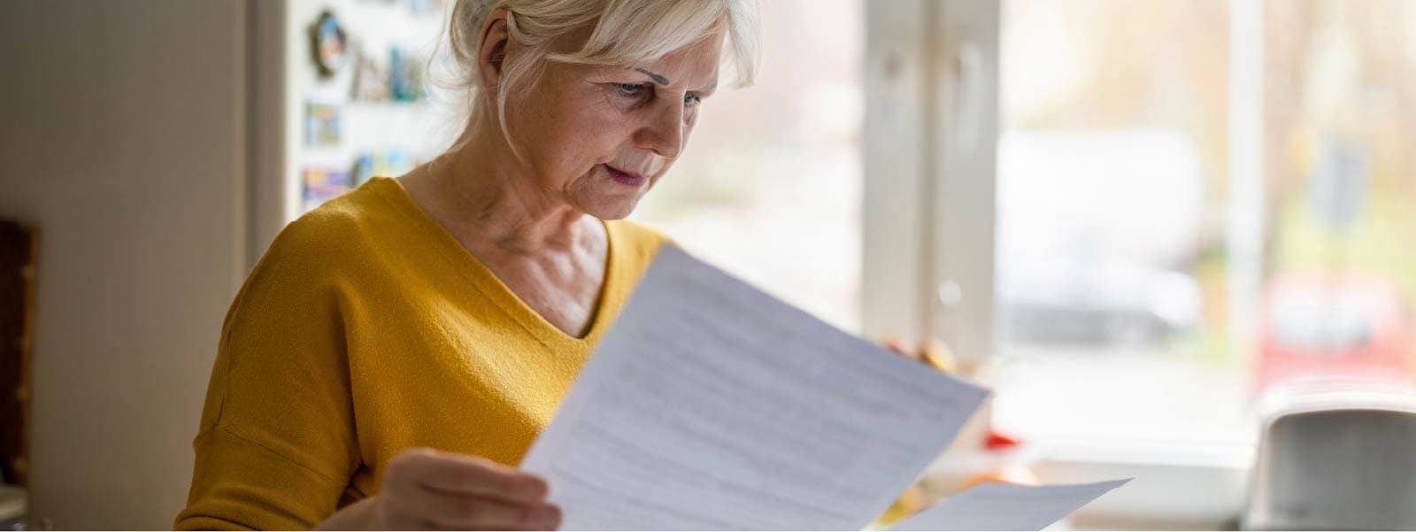 A woman examining documents to check for potential Medicare scams.