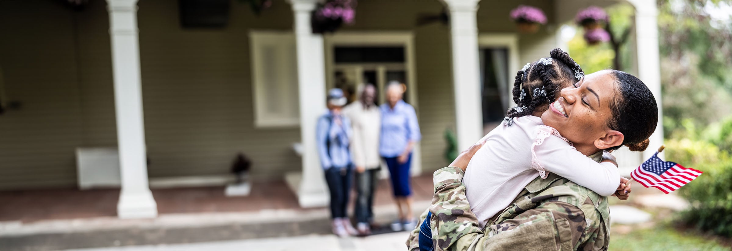 A female military member hugs her young daughter.