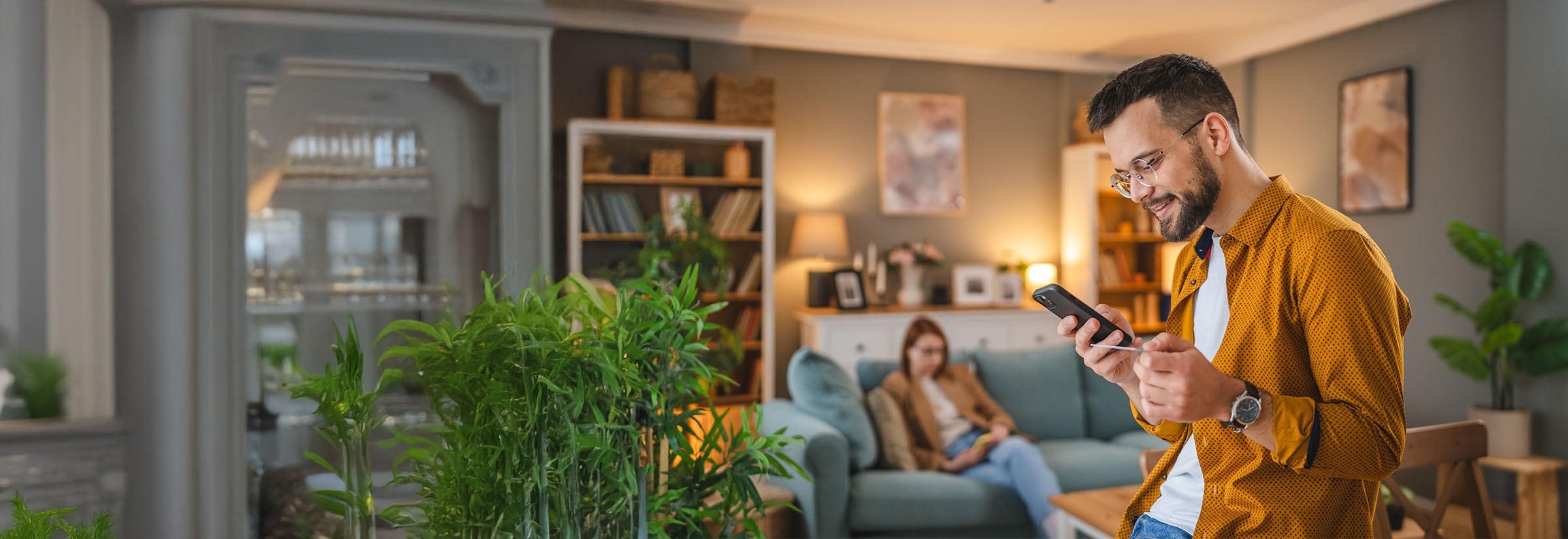 A man uses PayPal safely on his phone, steering clear of PayPal scams.