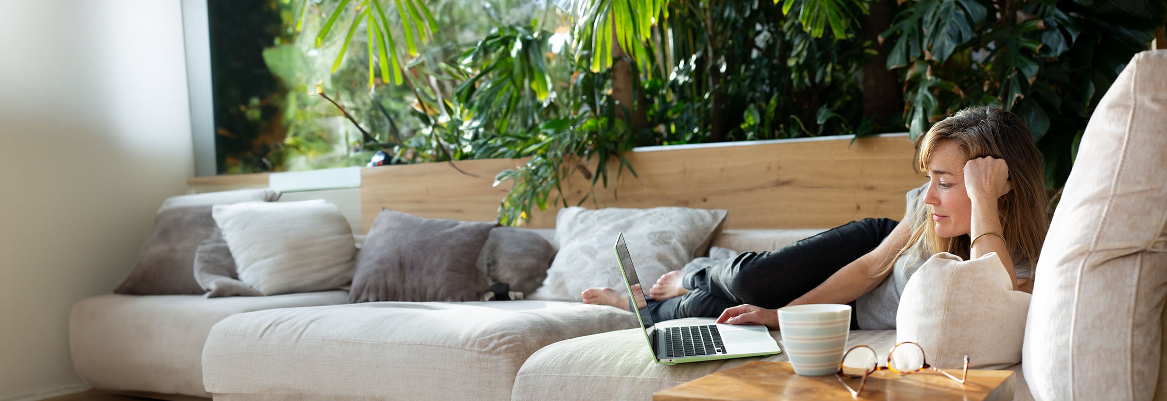 A woman and her child sit in front of a laptop computer, learning about Safer Internet Day together.