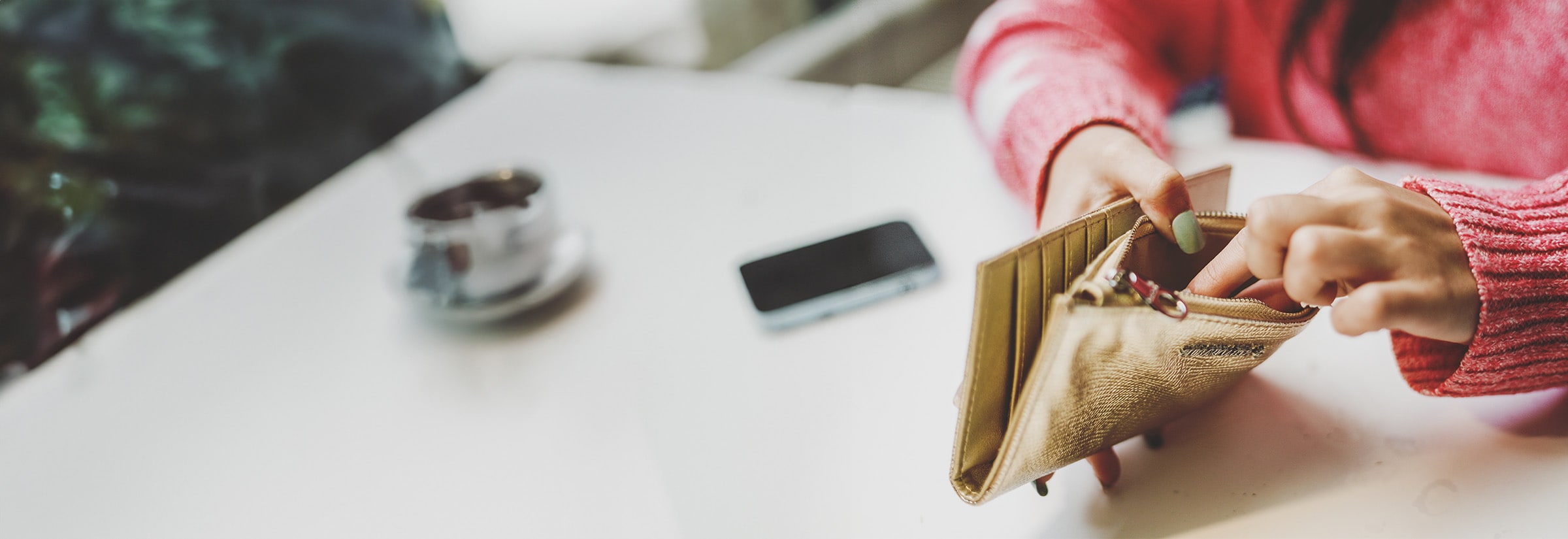 A woman pulls out her wallet to pay for a purchase at a local store.