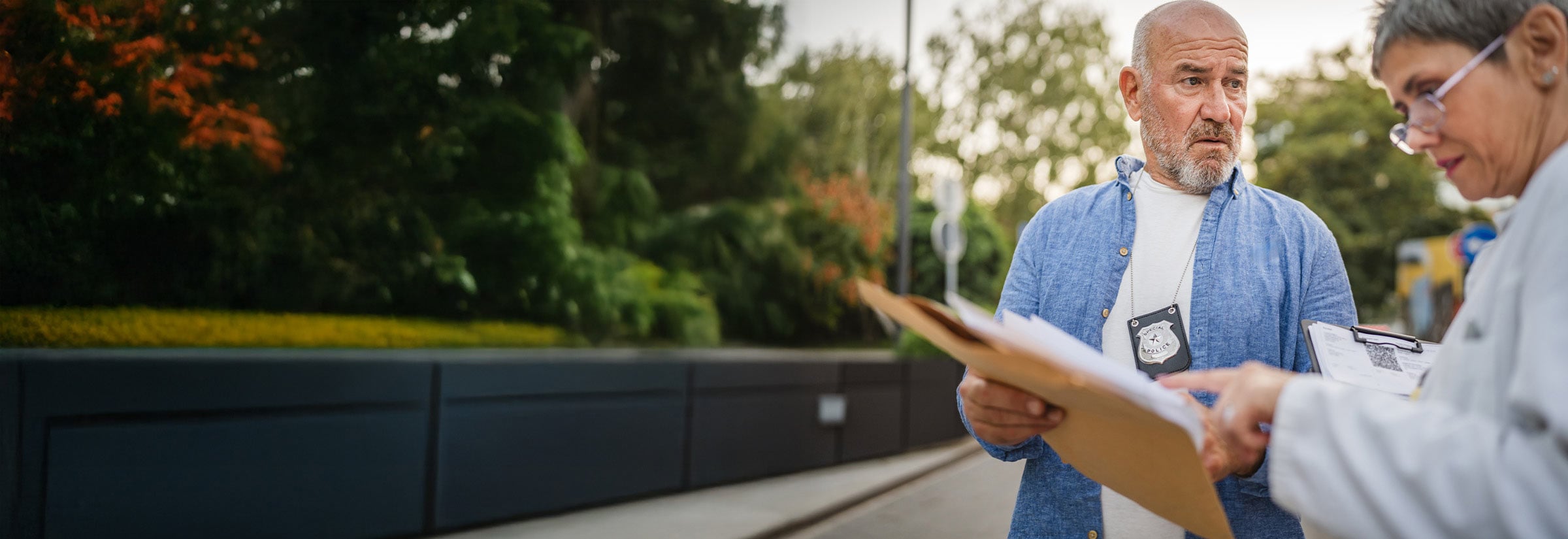 A victim looking through their stolen car registration report with a police officer.