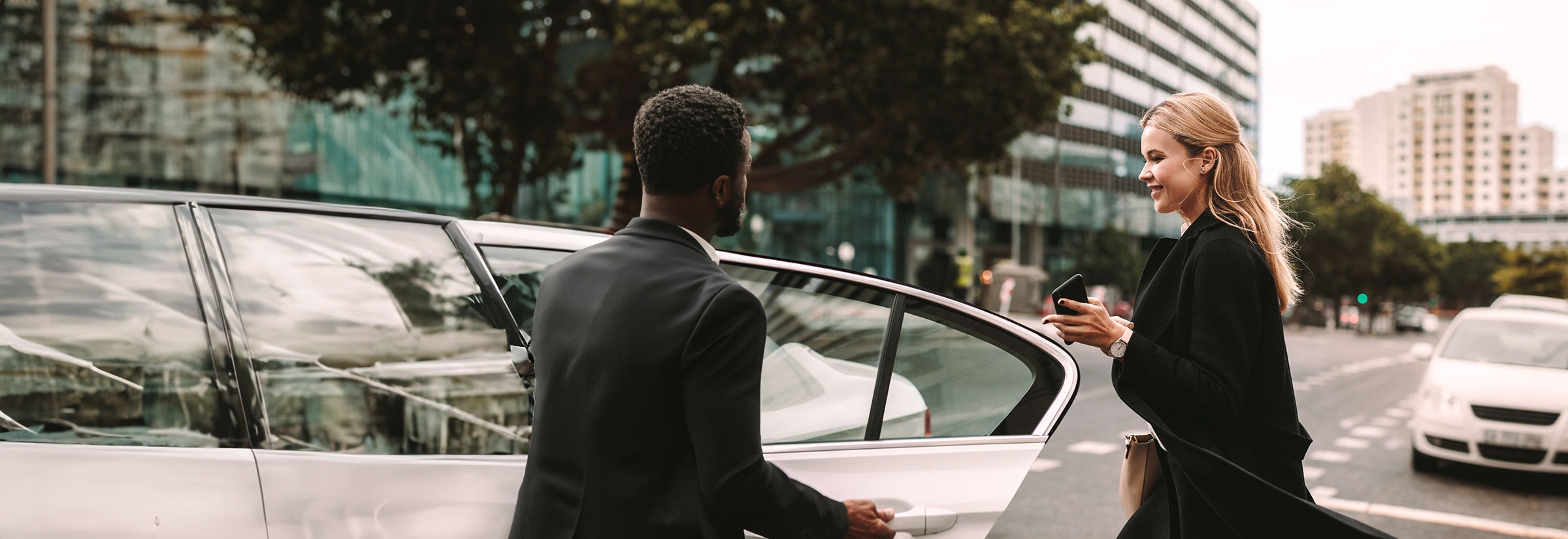 A man using his phone to hail a rideshare, highlighting the potential risks of using online services like Uber after a data breach.