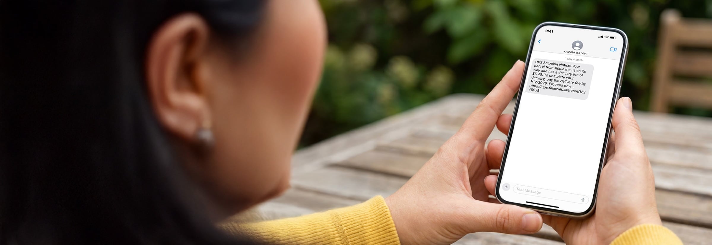 An image of a person receiving a text message that’s likely a UPS scam.