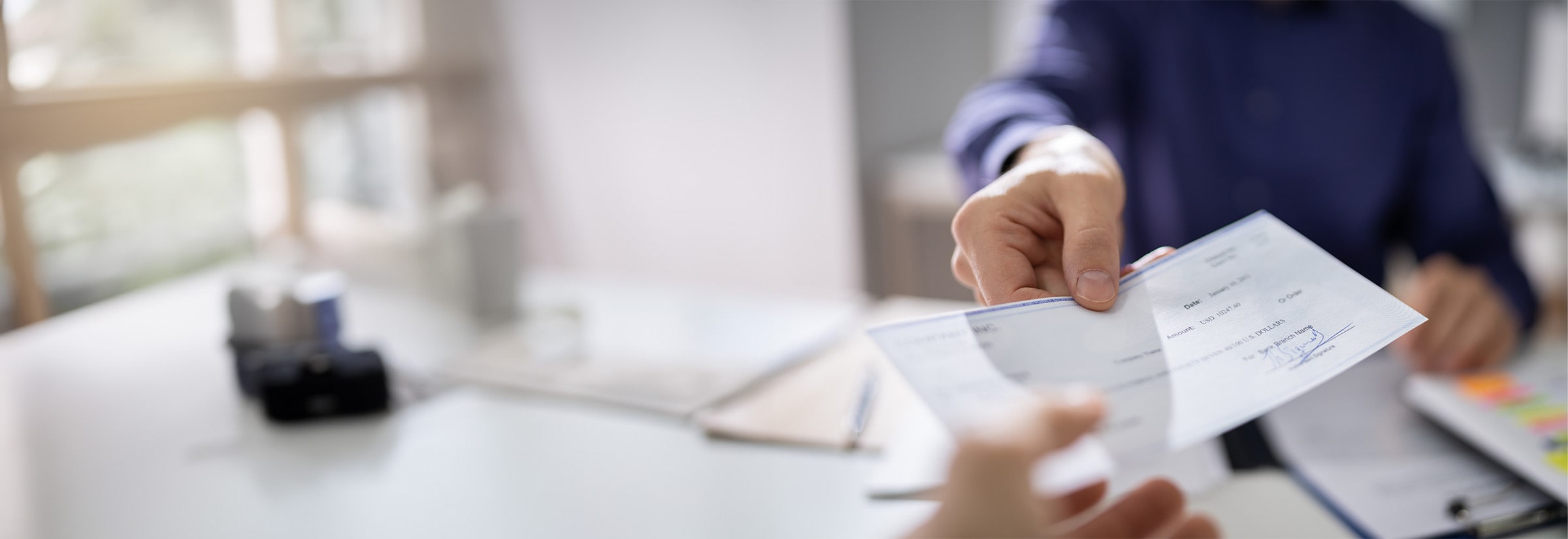 A person confidently signing a check for a secure financial transaction, illustrating the importance of identity protection from check fraud.