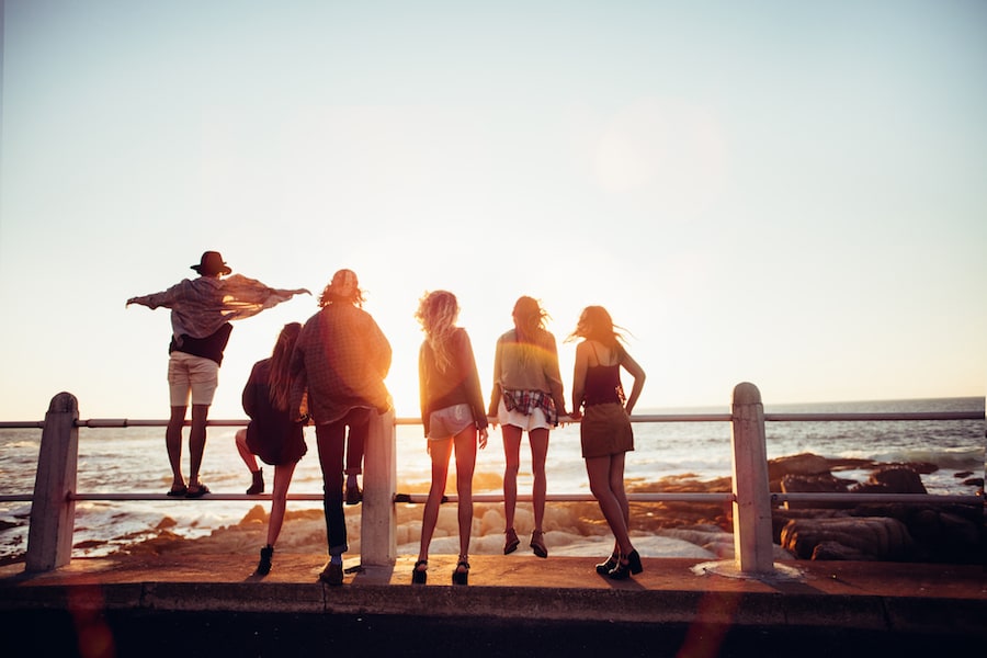 Group of people overlooking ocean at sunset