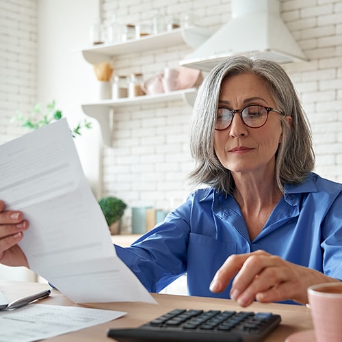 A woman examining documents to check for potential Medicare scams.