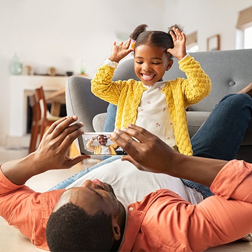 A father and daughter playing happily, knowing their family has identity theft protection.