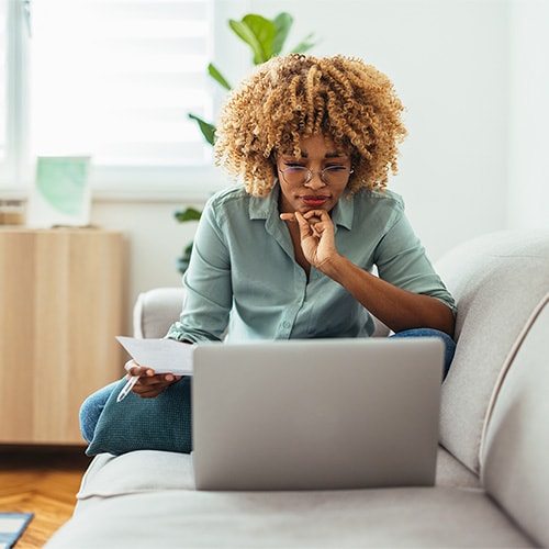 A woman who knows how to improve her credit score by making a credit card payment to lower her credit utilization and improve her payment history.