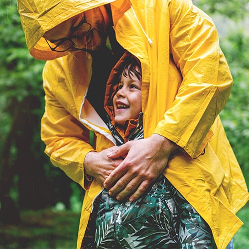 A parent shields their child, illustrating how a parent can help protect their child from identity theft.