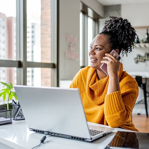 A woman on the phone seeing if her bank will refund scammed money.