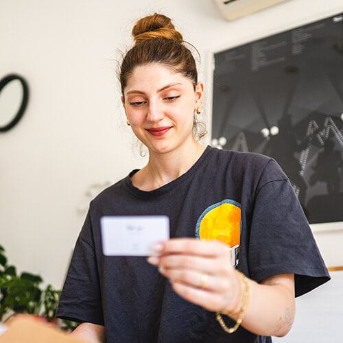 Woman holding and looking at a gift card.