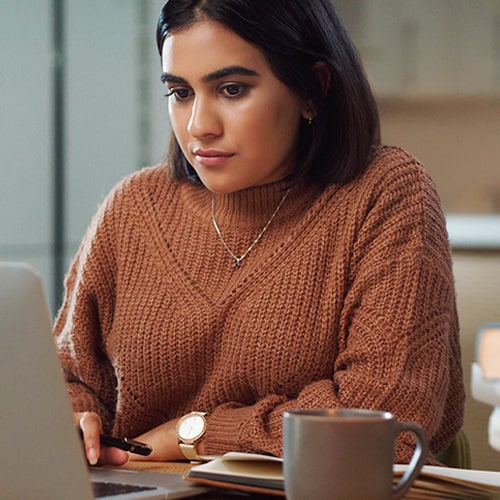 An image of a woman reading an email from a scammer.