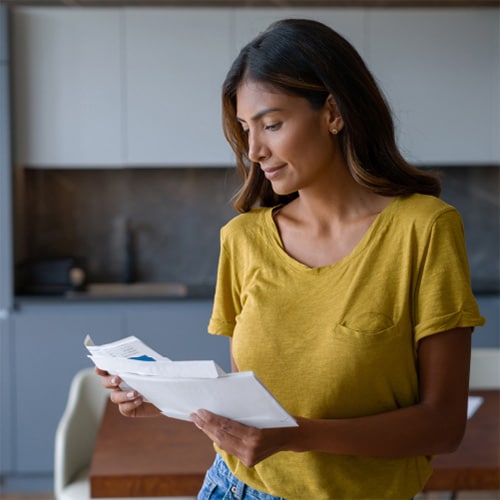 A woman looks to see if the check she got in the mail is fake.