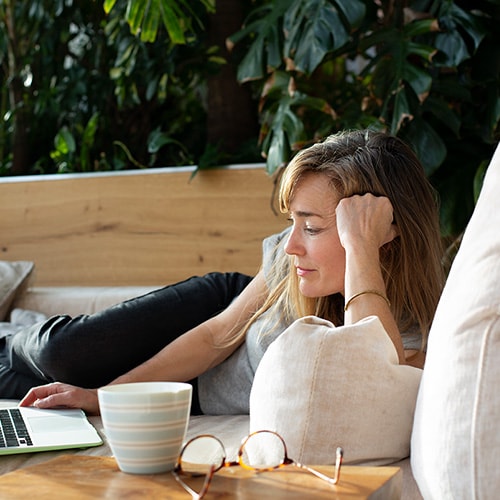 A woman and her child sit in front of a laptop computer, learning about Safer Internet Day together.