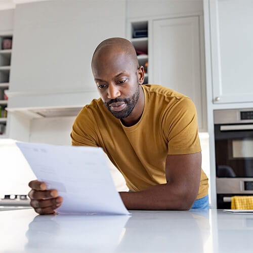 An image of a man checking his credit report after learning about synthetic identity theft.