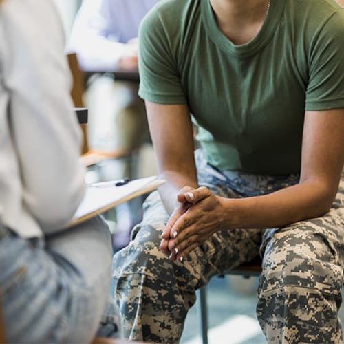 Woman wearing military attire sitting in a chair