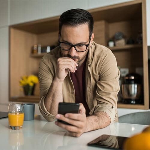 A man deciding whether a text message is a smishing scam or not.