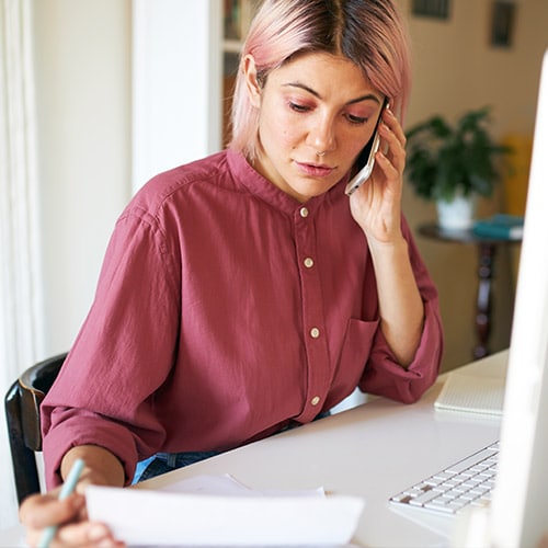 A woman at a desk working through the necessary steps following identity theft.