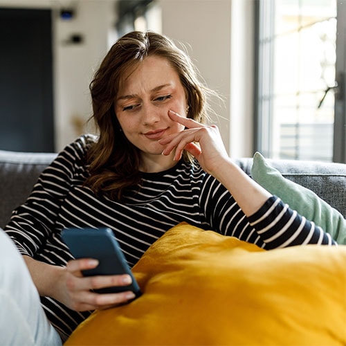 Image of a woman answering a phone call from an account services scammer.